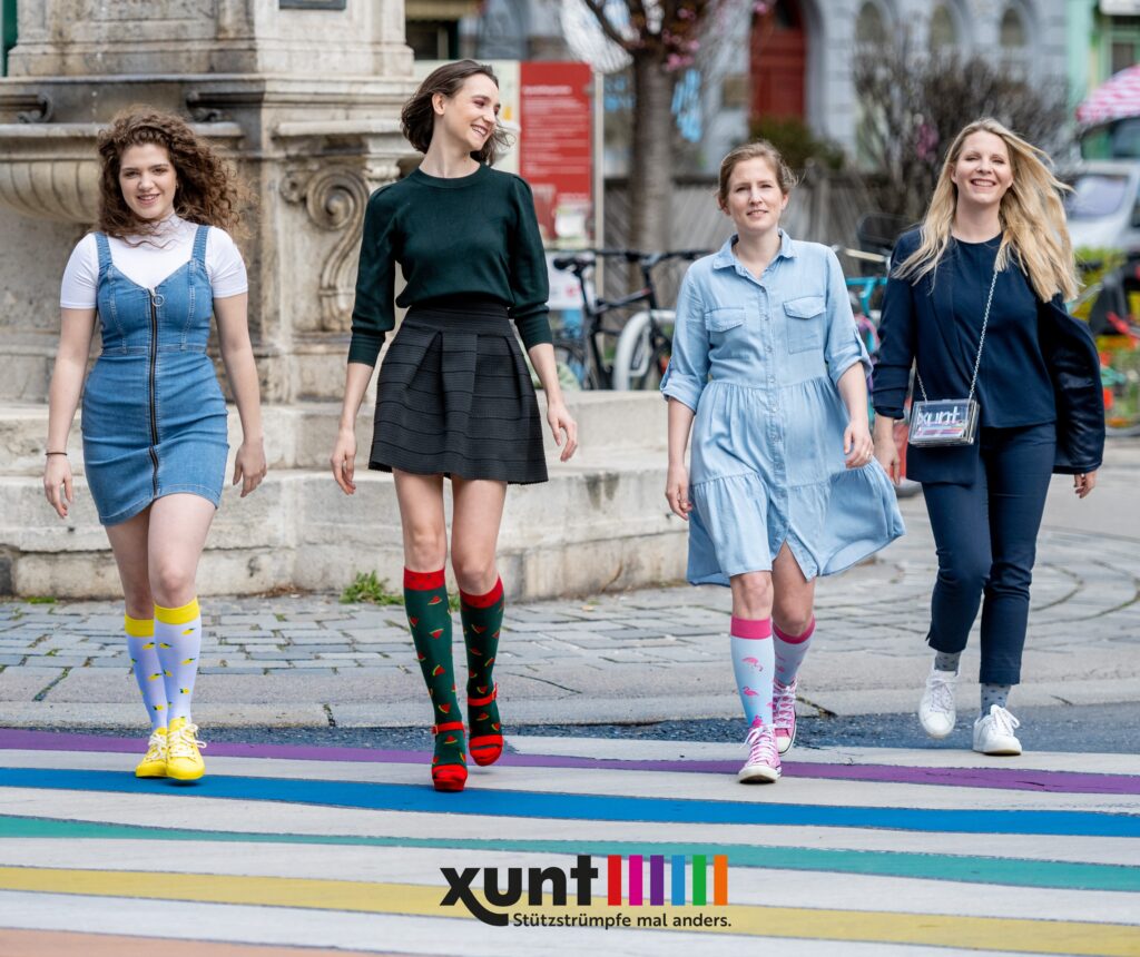 Personen mit den Xunt Strümpfen auf der Straße auf einen bunten Zebrastreifen